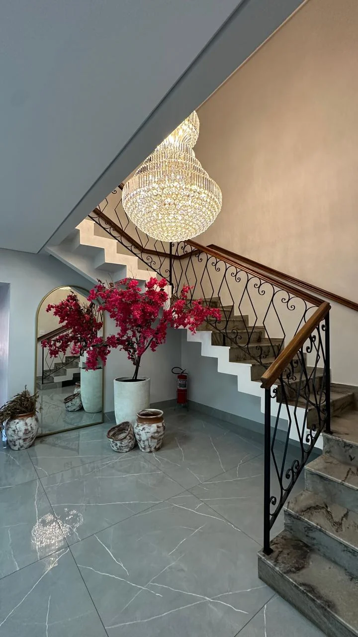 Hall de entrada da Clínica Luciana Andrade com lustre de cristal e escadaria